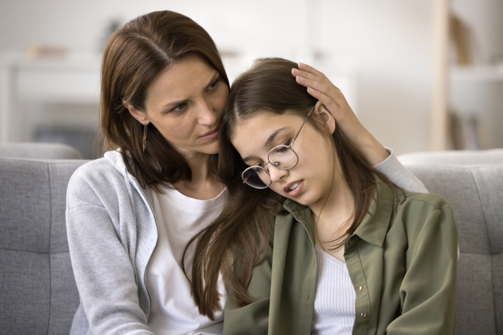Teen experienced bullying at school being comforted by her mother