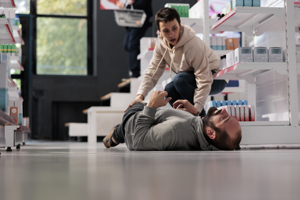 woman running to man having seizure in medical store