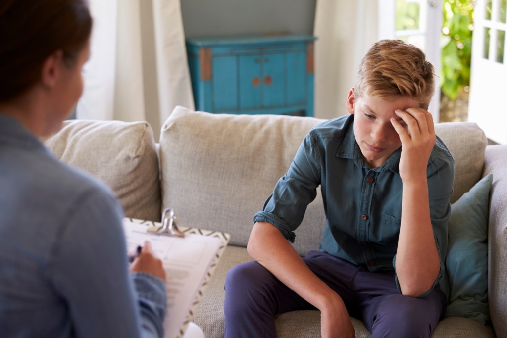 Teenage Boy With Trauma Problem Talking With Counselor
